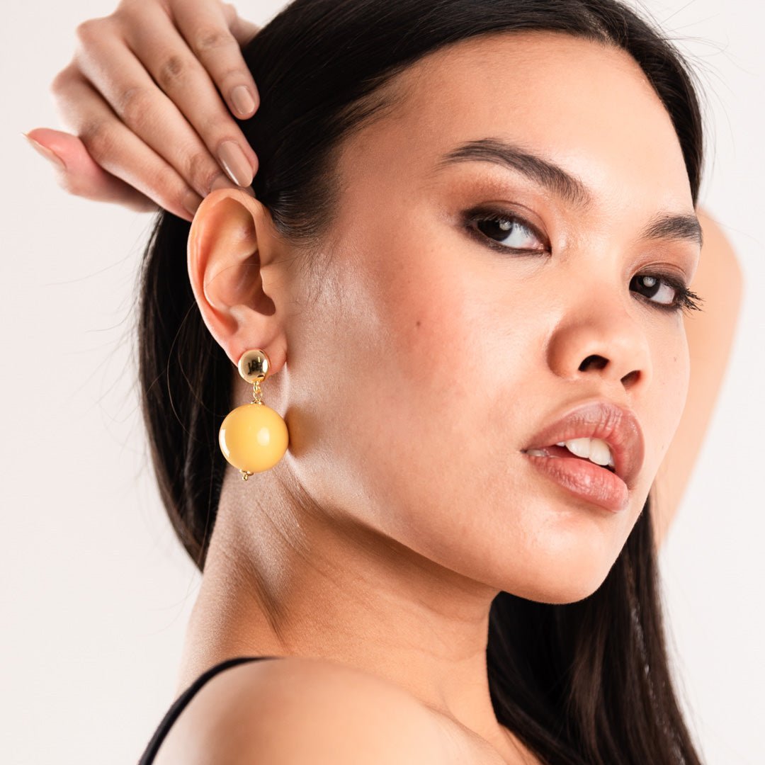 Orecchini in ottone con sfera XXL in acrilico giallo - Mya Accessories
