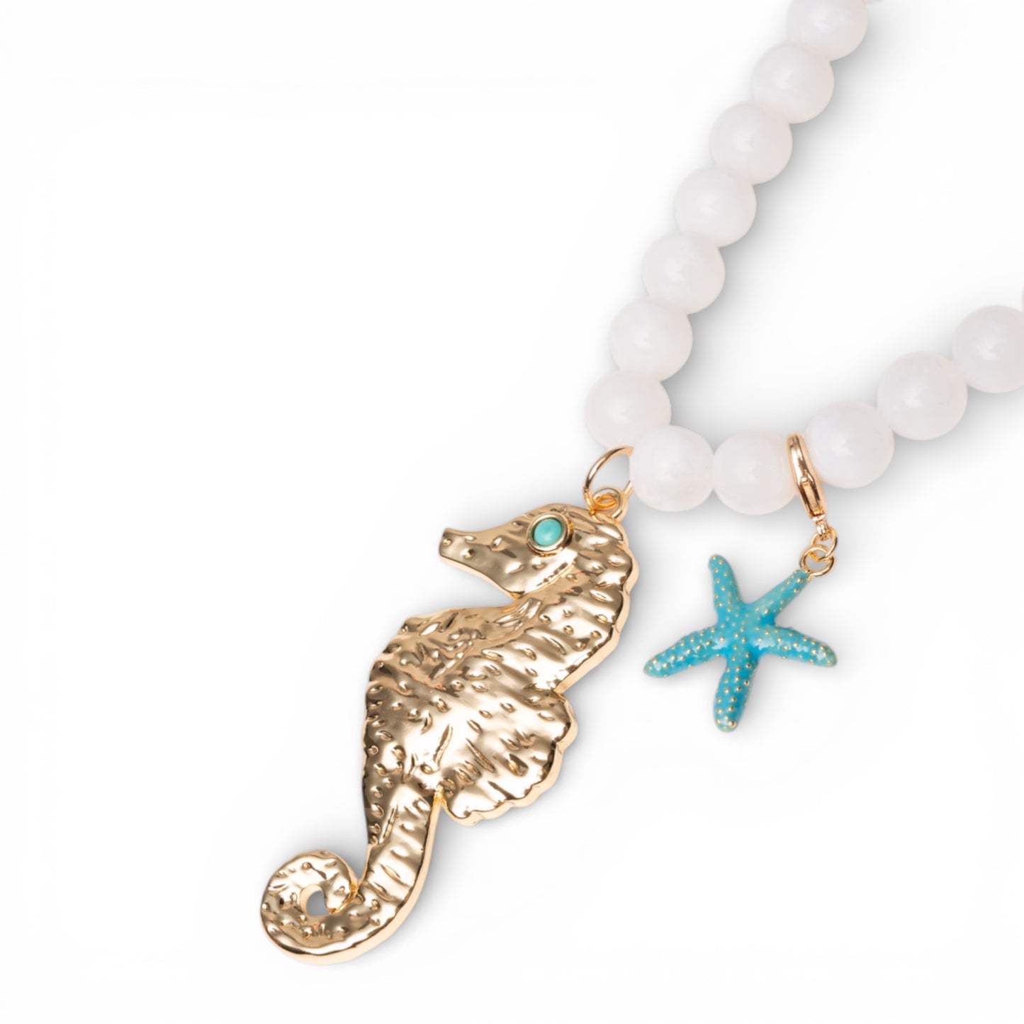 Collana lunga con sfere bianche in acrilico e pendente cavalluccio marino in metallo