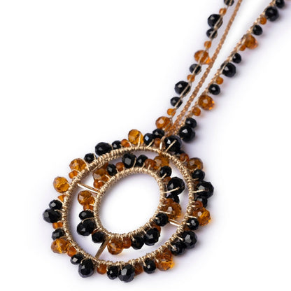 Collana lunga in tessuto con pendente, ricoperto di microcristalli in vetro arancio e nero - Mya Accessories