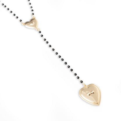Collana a rosario con pietre in acrilico nere e pendente a cuore in metallo