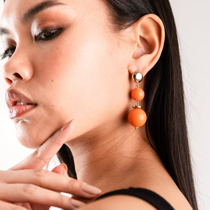 Orecchini con rondelle in metallo pendente con due sfere in acrilico arancio - Mya Accessories