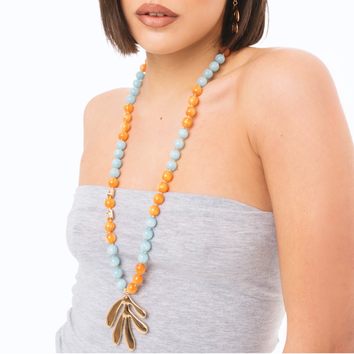 Collana lunga con sfere in acrilico arancio e turchesi, pendente a foglia