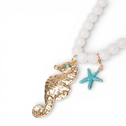 Collana lunga con sfere bianche in acrilico e pendente cavalluccio marino in metallo