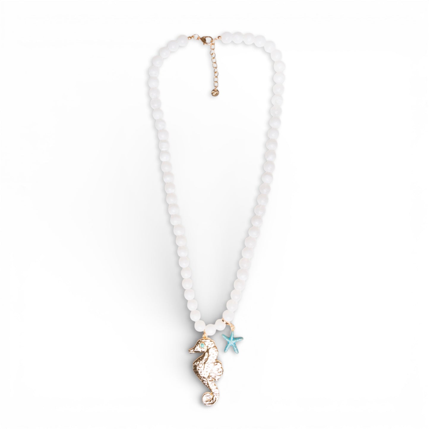Collana lunga con sfere bianche in acrilico e pendente cavalluccio marino in metallo