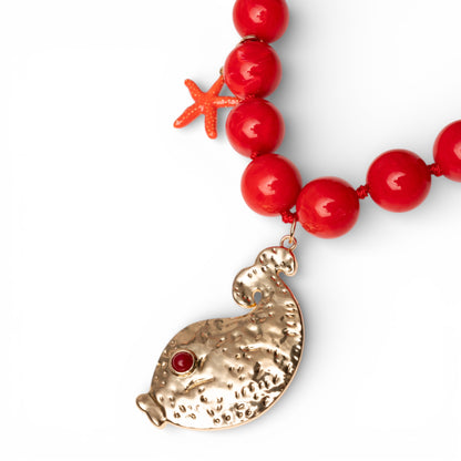 Collana lunga con sfere rosse in acrilico e pendente pesciolino in metallo