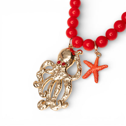 Collana lunga con sfere rosse in acrilico e pendente polipetto in metallo